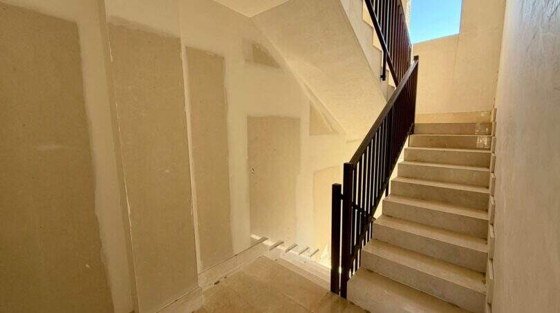 Treppenhaus mit Marmortreppe und dunklem Holzgeländer im Rohbau-Renditeobjekt in Manacor