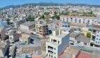 Luftaufnahme von Manacor mit Rohbau-Renditeobjekt, Stadtpanorama und Gebirge im Hintergrund