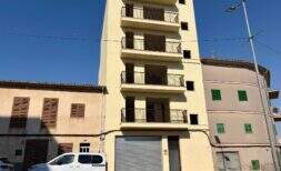 Edificio residencial de varias plantas en fase de obra bruta con balcones en Manacor, flanqueado por edificios vecinos, con una fachada soleada.