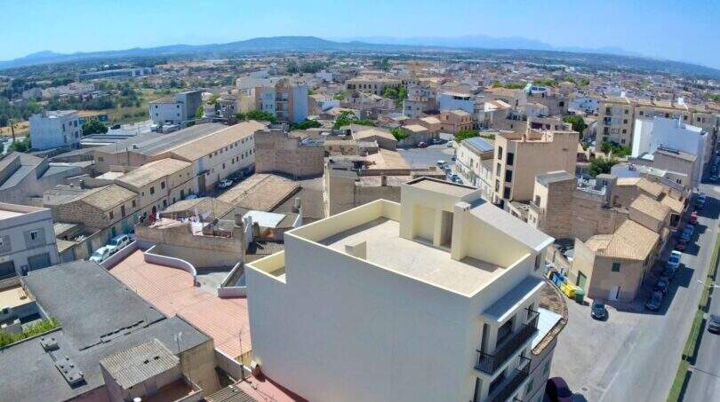 Luftaufnahme von Manacor mit Rohbau im Vordergrund, umgeben von mediterraner Stadtbebauung und Bergpanorama