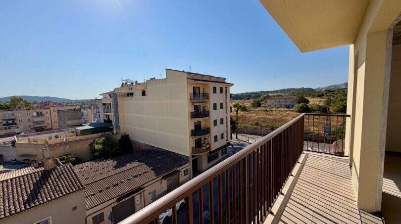 Balkon mit Holzgeländer und Blick auf Manacors Stadtbild, Felder und Hügel bei sonnigem Wetter