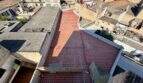Luftaufnahme der Dachterrasse eines Rohbaus in Manacor mit roten Fliesen und umliegender Altstadtbebauung.