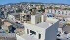 Luftaufnahme eines modernen Rohbaus in Manacor mit kubischer Architektur und Stadtpanorama im Hintergrund.