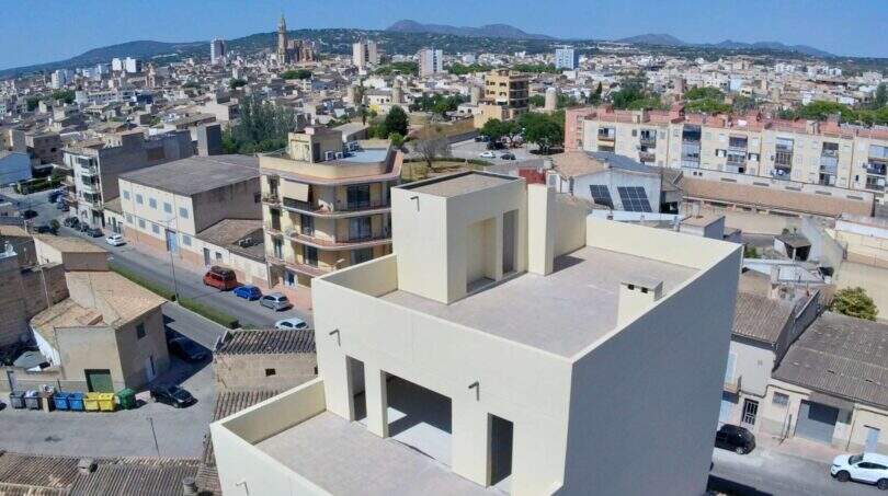 Luftaufnahme eines modernen Rohbaus in Manacor mit kubischer Architektur und Stadtpanorama im Hintergrund.