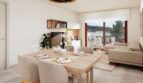 Helles Wohn-Esszimmer mit Holztisch, Sofabereich und Zugang zur Terrasse in Erdgeschoss-Wohnung, Canyamel