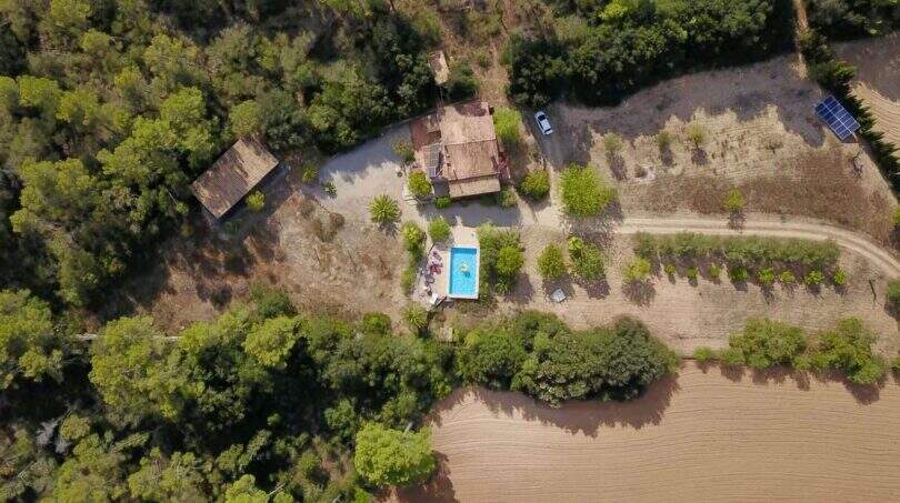 Luftaufnahme einer idyllischen Finca bei Vilafranca de Bonany mit Pool, Nebengebäude und Solaranlage inmitten grüner Natur.