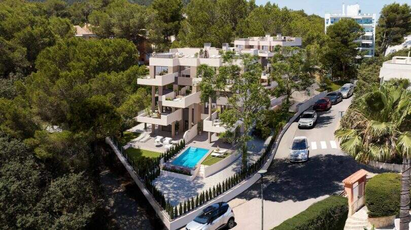Luftaufnahme eines modernen Wohnkomplexes mit Pool, Balkonen und Grünflächen in Canyamel