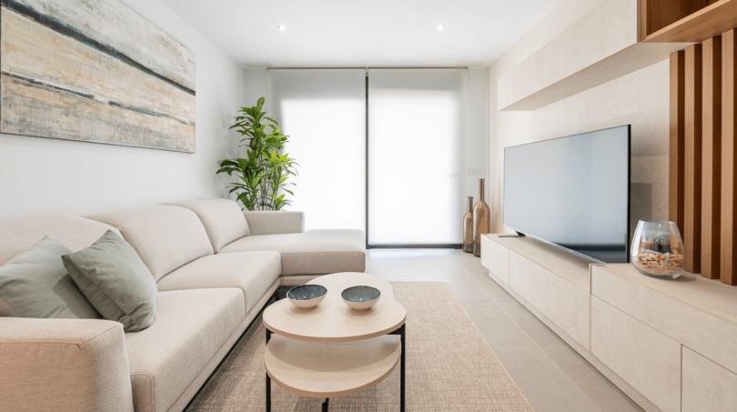 Helles Wohnzimmer mit Ecksofa, Flachbild-TV und Holzmöbeln in moderner Wohnung in Cala Ratjada