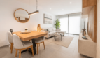 Helles Wohn- und Esszimmer mit Holzmöbeln, grauem Sofa und großer Terrassentür in moderner Wohnung Cala Ratjada