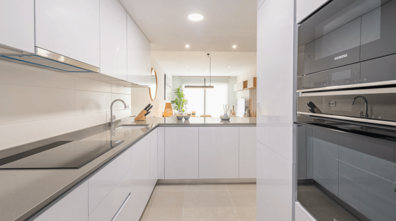 Moderne weiße Einbauküche mit Siemens-Geräten und grauer Arbeitsplatte in EG-Wohnung Cala Ratjada