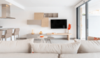 Helles Wohnzimmer mit modernem TV-Wandregal, Sofa und Zugang zur Terrasse in DHH Cala Ratjada