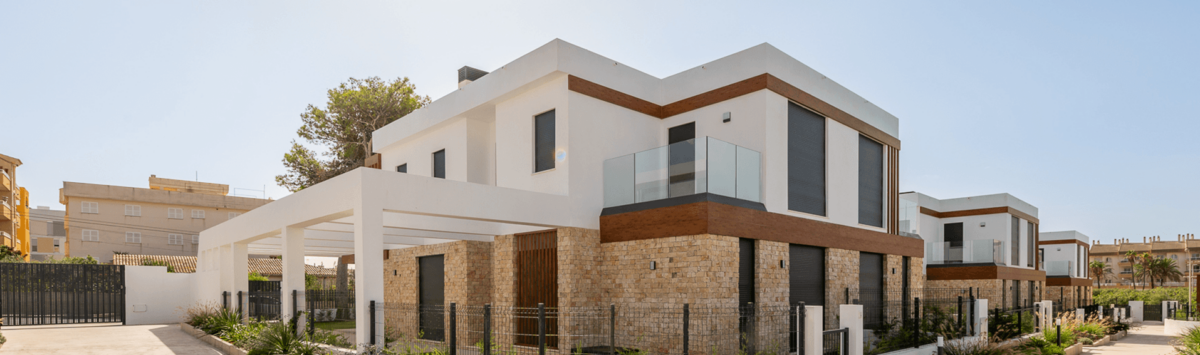 Moderne Doppelhaushälfte in Cala Ratjada mit Natursteinverkleidung, Glasbalkon und gepflegtem Vorgarten.