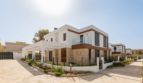Moderne Doppelhaushälfte in Cala Ratjada mit Natursteinverkleidung, Glasbalkon und gepflegtem Vorgarten.