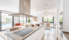 Modern Open Kitchen with Island, Range Hood and View of Pool and Living Area in Semi-Detached House Cala Ratjada
