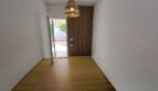 Heller Eingangsbereich mit Holzboden, Holzlamellenwand und Rattanlampe im Meereslinie-Apartment Portocolom