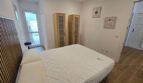 Helles Schlafzimmer mit Doppelbett, Holzschränken und Wandkunst im Hafenapartment Portocolom