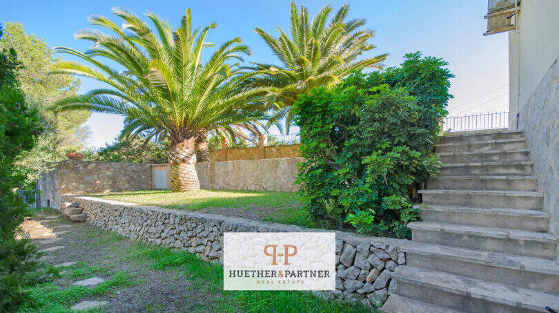 Gepflegter Garten der Finca in Son Macià mit Palmen, Natursteinmauern und Treppenaufgang
