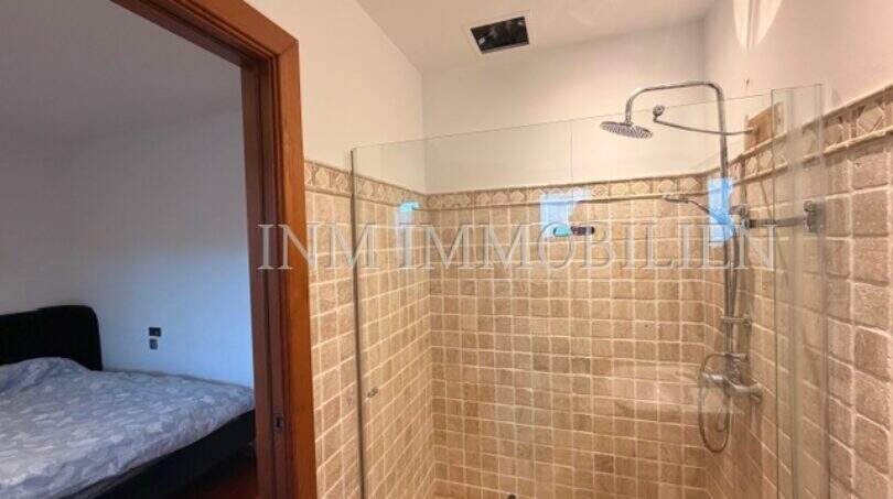 Modernes Duschbad mit Natursteinfliesung und Regendusche, angrenzend an Schlafzimmer in Villa Marratxí