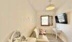 Luminosa habitación infantil con sofá, espejo de pared, televisor y peluche en apartamento renovado en Palma