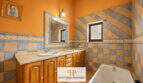 Badezimmer der Finca Felanitx mit Doppelwaschbecken, Whirlpool-Badewanne und dekorativen Wandfliesen