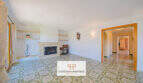 Helles Wohnzimmer der Finca Son Macià mit Kamin, Mosaikfliesen und Durchgang zum Flur.