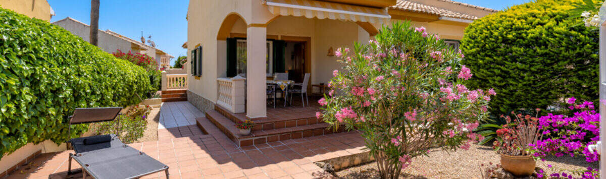 Sonnige Terrasse mit Terrakottafliesen, Oleander und Bougainvillea vor mediterranem Doppelhaus in Cala Murada