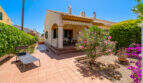 Sonnige Terrasse mit Terrakottafliesen, Oleander und Bougainvillea vor mediterranem Doppelhaus in Cala Murada