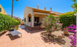 Sonnige Terrasse mit Terrakottafliesen, Oleander und Bougainvillea vor mediterranem Doppelhaus in Cala Murada