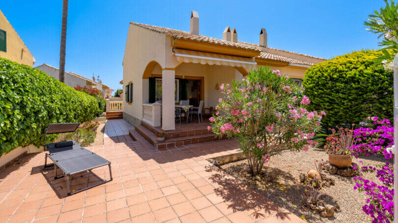 Sonnige Terrasse mit Terrakottafliesen, Oleander und Bougainvillea vor mediterranem Doppelhaus in Cala Murada