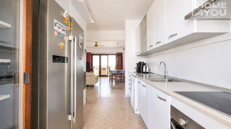Moderne Küche mit Einbaugeräten, weißen Fronten und Blick ins helle Wohnzimmer, Ferienwohnung Ses Salines