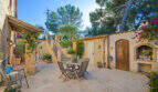 Sonniger Innenhof der Finca Son Macià mit Sitzgruppe, Grillnische und mediterranem Bepflanzung