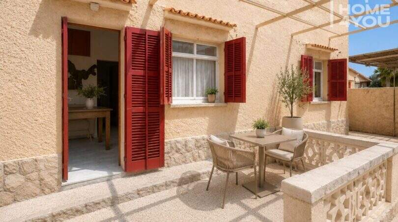 Sonnige Terrasse mit Sitzgruppe, roten Fensterläden und Pergola, Erdgeschosswohnung in Cala Llombards