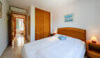 Helles Schlafzimmer mit Doppelbett, Holzeinbauschrank und Klimaanlage im Doppelhaus Cala Murada.