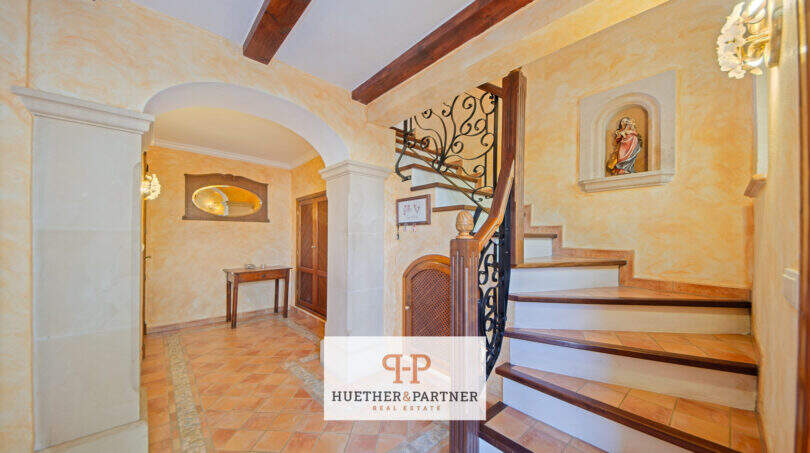 Eleganter Eingangsbereich der Finca in Son Macià mit Natursteintreppe, Schmiedeeisen-Geländer und Terrakottaboden.