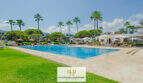 Großer Gemeinschaftspool mit Palmen, Sonnenschirmen und gepflegter Gartenanlage in Cala d'Or