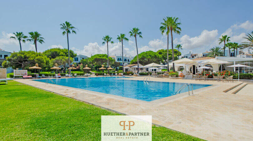 Großer Gemeinschaftspool mit Palmen, Sonnenschirmen und gepflegter Gartenanlage in Cala d'Or