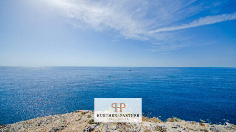 Felsküste in 1. Meereslinie Porto Cristo mit weitem Blick auf das tiefblaue Mittelmeer und klarem Himmel