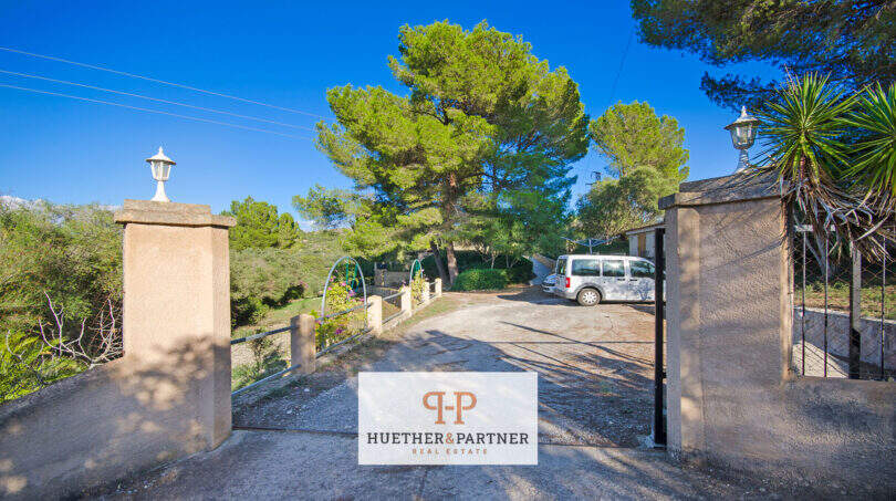 Einfahrt der Finca Son Macià mit steinernen Torpfeilern, Eisentor und mediterranem Baumbestand