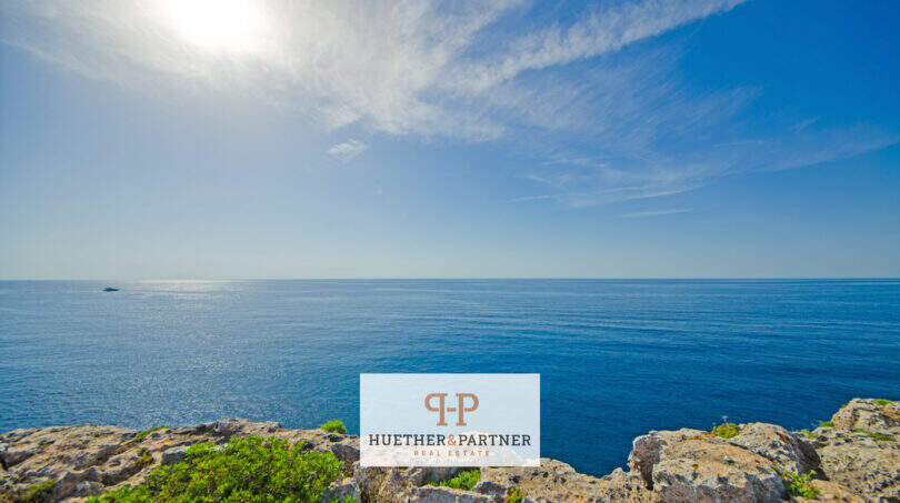 Felsküste in 1. Meereslinie Porto Cristo mit weitem Meerblick unter blauem Himmel