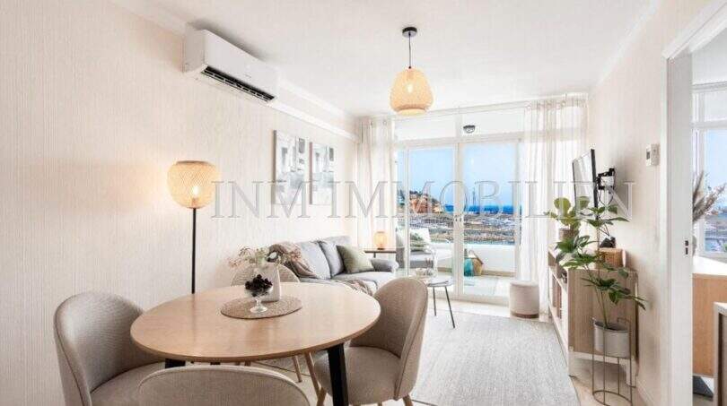 Luminosa sala de estar con mesa de comedor, sofá y vistas al mar a Port Adriano, aire acondicionado y balcón