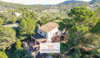 Luftaufnahme einer mediterranen Finca in Son Macià, umgeben von Pinien, mit Terrasse und Blick ins grüne Tal.