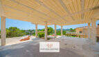 Überdachte Rohbau-Terrasse mit Säulen und Panoramablick auf Landschaft und Nachbarvilla in Cala Romántica