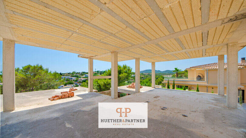 Überdachte Rohbau-Terrasse mit Säulen und Panoramablick auf Landschaft und Nachbarvilla in Cala Romántica