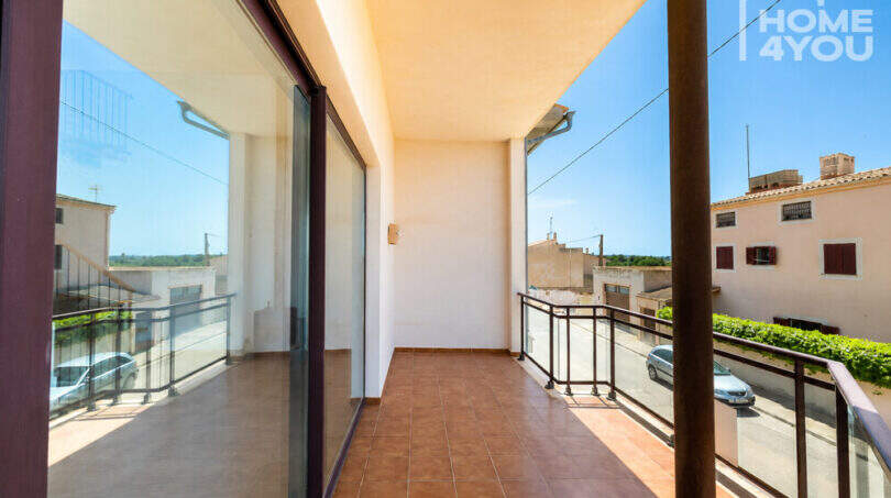 Sonniger Balkon mit Glasgeländer und Blick auf die Straße und Nachbarschaft in Ses Salines