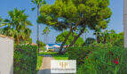 Gepflegter Gartenweg mit Palmen und Pinien, Blick aufs Meer in Apartmentanlage Cala d'Or