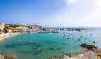 Vista panorámica de la bahía Port Adriano con agua azul turquesa, playa y marina en primera línea de mar, Calvià
