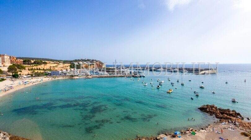 Vista panorámica de la bahía Port Adriano con agua azul turquesa, playa y marina en primera línea de mar, Calvià