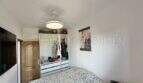 Luminoso dormitorio del apartamento en Palma con cama doble, armario abierto y ventilador de techo.