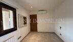 Habitación luminosa y vacía con aire acondicionado, radiador, suelo de mármol y ventana con vista al jardín en villa Marratxí