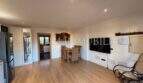 Heller Wohnbereich der Gästewohnung in Villa Marratxí mit Holzboden, Esstisch, TV-Wand und Schaukelsessel
